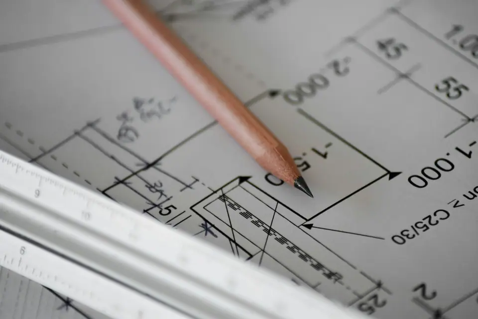 A pencil resting on an architectural drawing