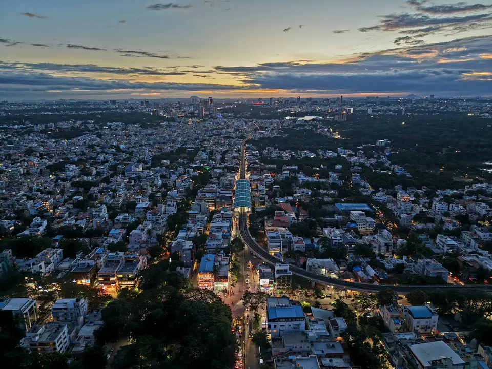 Bengaluru at dusk from above, with lit streets and buildings