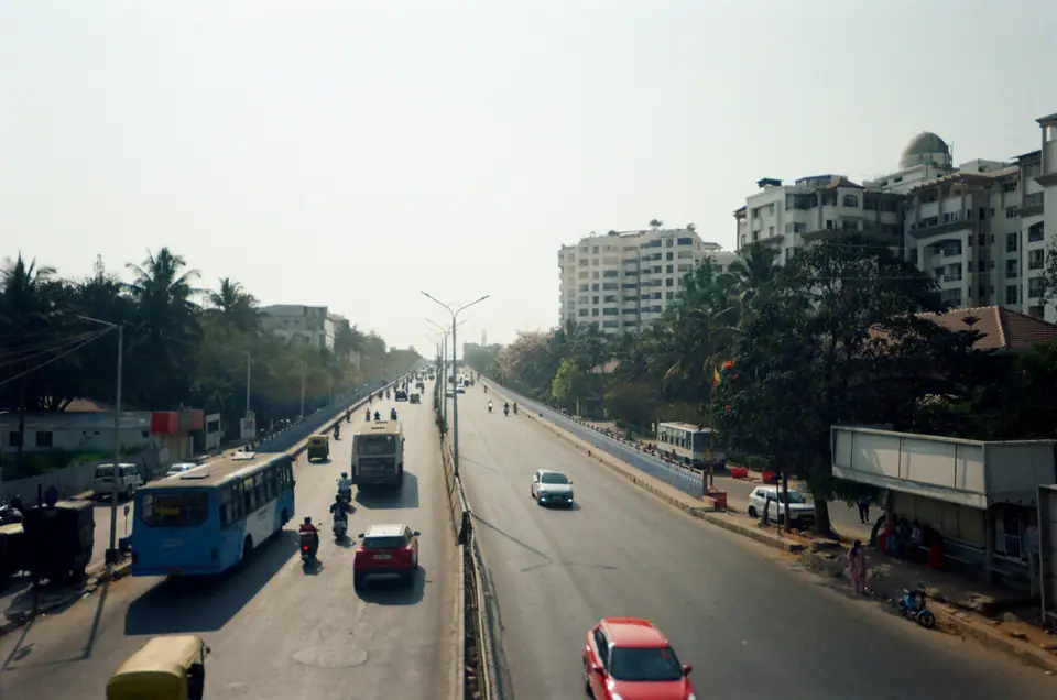 A wide Bengaluru road lined with trees and apartment buildings