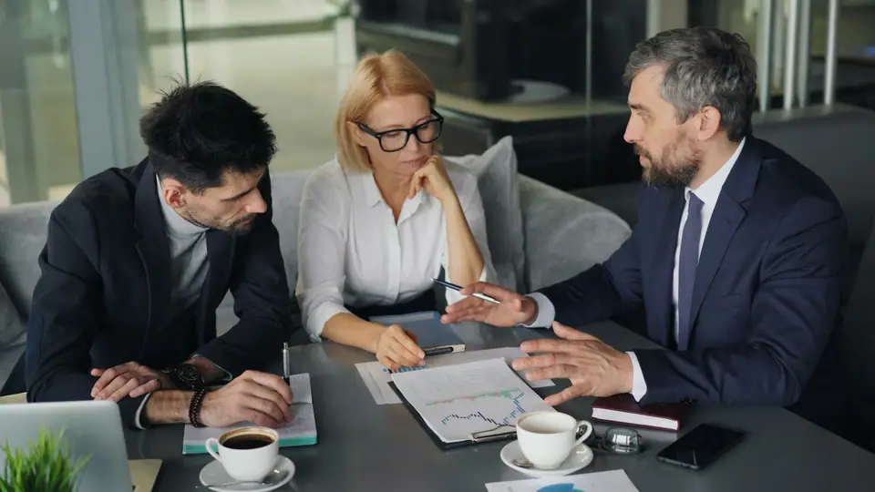 People around a meeting table discussing documents