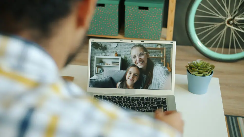A man on a video call with family on a laptop