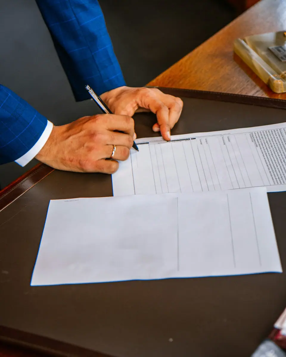 A person filling in and signing a printed form